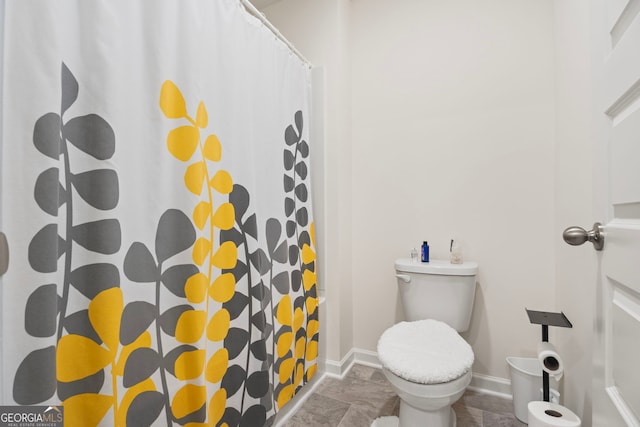 bathroom featuring walk in shower and toilet