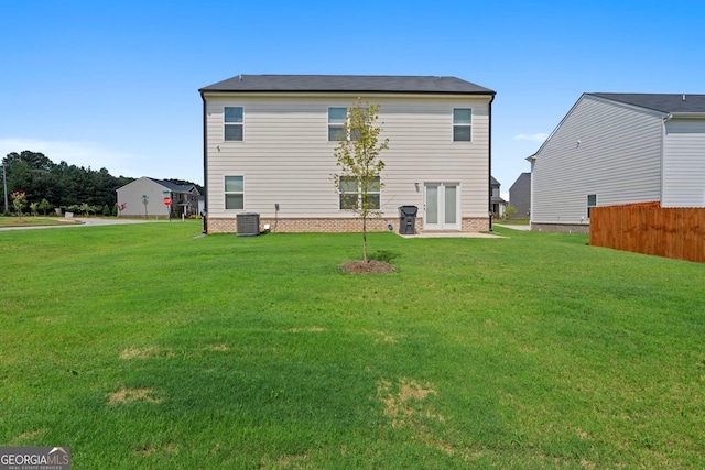 rear view of house with a yard and central air condition unit