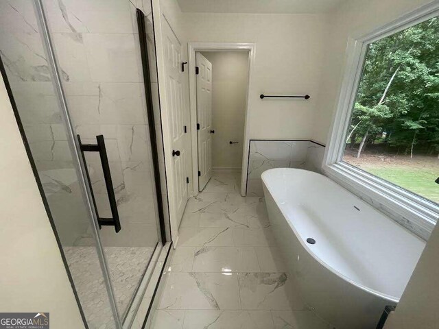 bathroom with a wealth of natural light, tile patterned flooring, and plus walk in shower