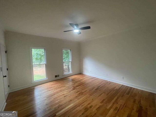 spare room with wood-type flooring and ceiling fan