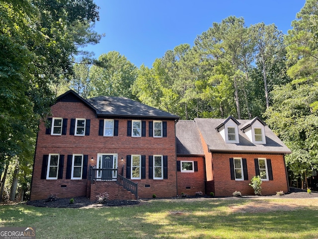 colonial inspired home featuring a front lawn