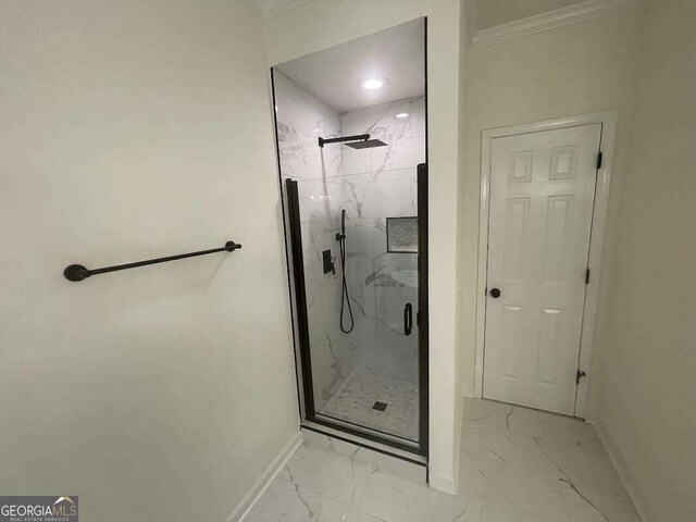 bathroom with a shower with shower door, ornamental molding, and tile patterned floors