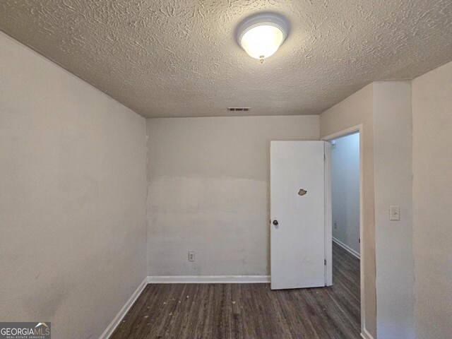 unfurnished room featuring a textured ceiling and wood-type flooring