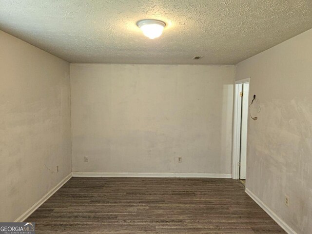 empty room with a textured ceiling and hardwood / wood-style floors