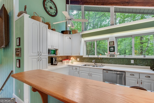 kitchen with a wealth of natural light, white cabinetry, sink, and appliances with stainless steel finishes