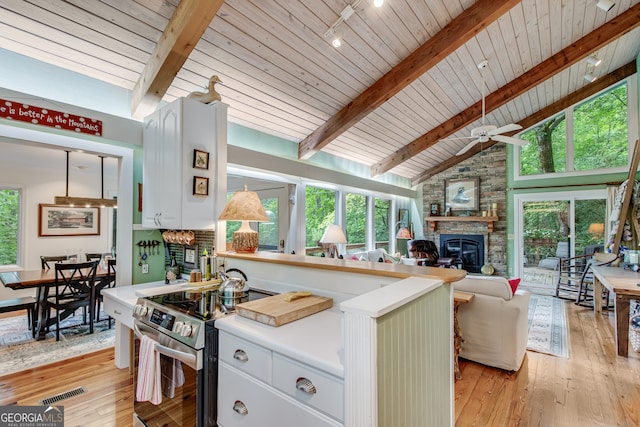 kitchen with wooden ceiling, stainless steel range with electric cooktop, ceiling fan, light wood-type flooring, and a fireplace