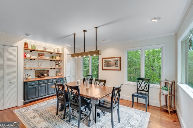 dining area with light hardwood / wood-style flooring and ornamental molding