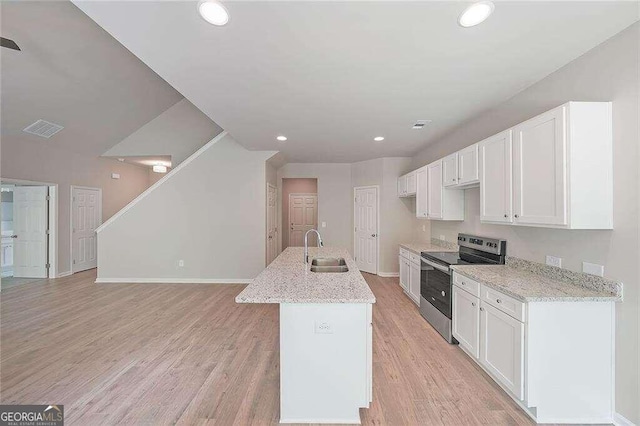 kitchen with sink, stainless steel electric range oven, light wood-type flooring, and white cabinetry