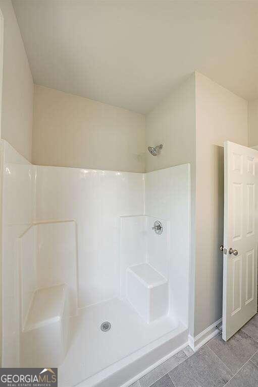 bathroom with tile patterned flooring and walk in shower