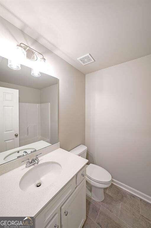 bathroom featuring vanity, toilet, and tile patterned flooring