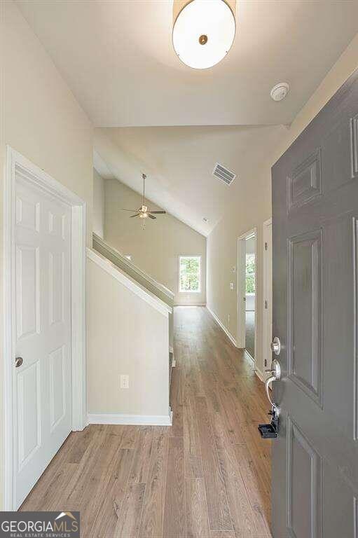 entryway featuring light hardwood / wood-style flooring, ceiling fan, and vaulted ceiling