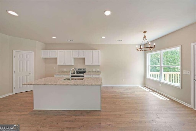 kitchen with light stone countertops, light hardwood / wood-style flooring, and sink