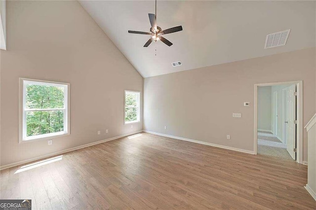 unfurnished room with ceiling fan, wood-type flooring, and high vaulted ceiling