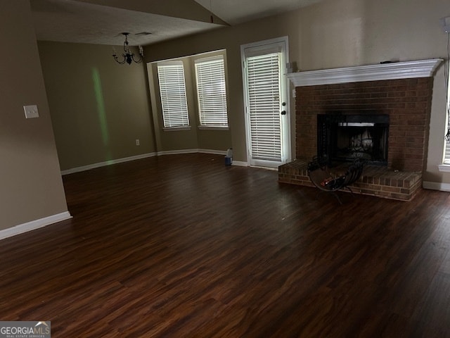 unfurnished living room with a fireplace, lofted ceiling, dark hardwood / wood-style flooring, and a wealth of natural light