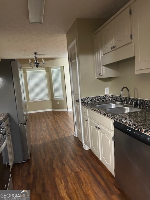 kitchen featuring stainless steel appliances, white cabinetry, sink, dark hardwood / wood-style flooring, and a notable chandelier