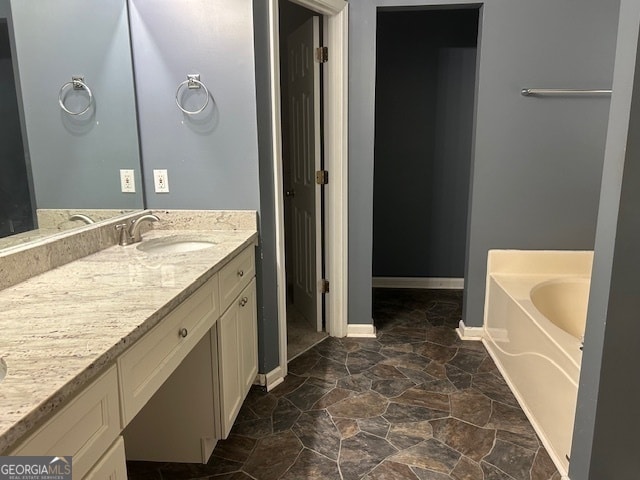 bathroom with tile patterned floors, a bath, and vanity