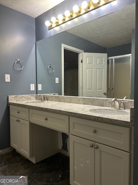 bathroom featuring tile patterned flooring, a textured ceiling, vanity, and a shower with shower door