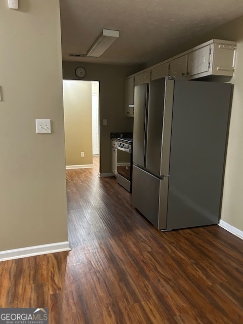 kitchen featuring range, stainless steel refrigerator, dark hardwood / wood-style flooring, and white cabinets