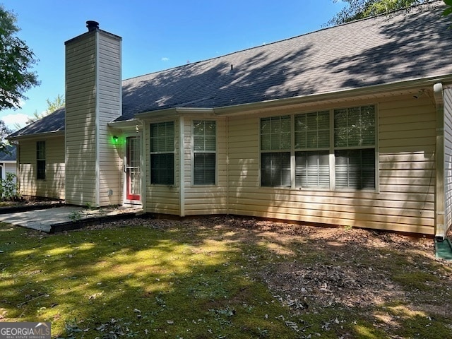 rear view of house with a yard