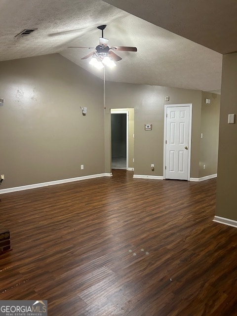 unfurnished room with ceiling fan, vaulted ceiling, dark wood-type flooring, and a textured ceiling