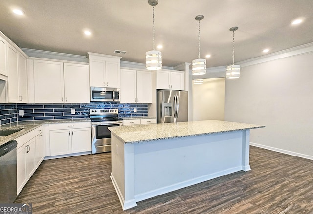 kitchen featuring ornamental molding, stainless steel appliances, backsplash, and a center island