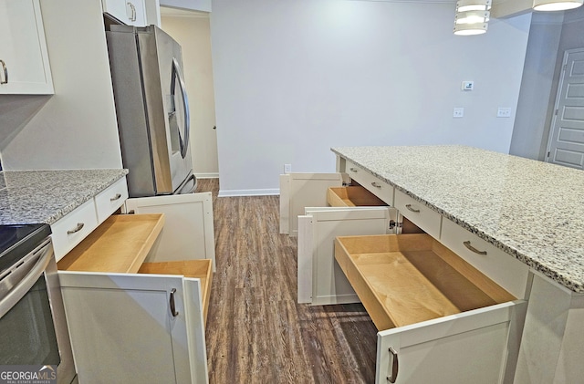 kitchen featuring dark wood-style floors, white cabinets, stainless steel fridge, and light stone counters