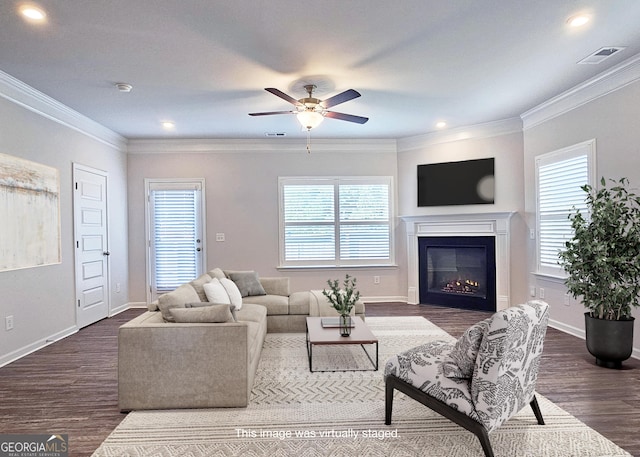 living area with a wealth of natural light, dark wood finished floors, and visible vents