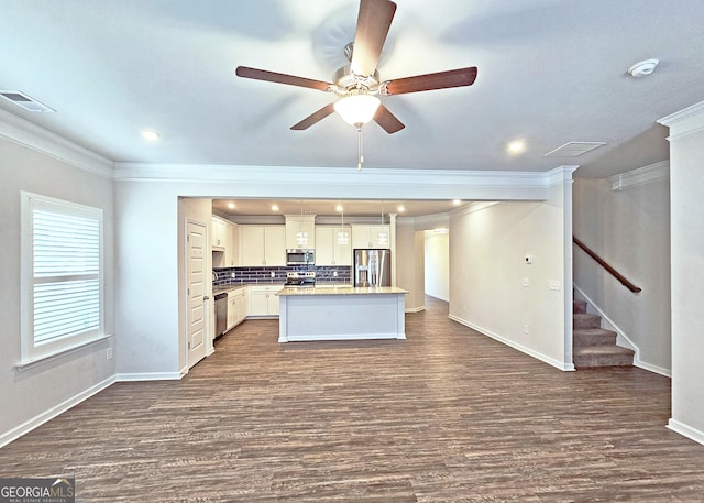 kitchen with visible vents, backsplash, appliances with stainless steel finishes, dark wood-type flooring, and a kitchen island