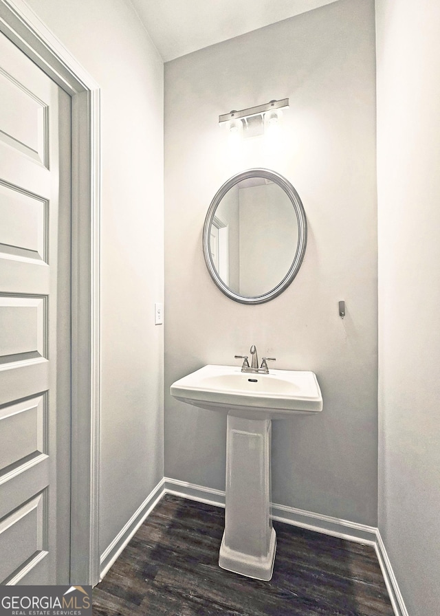 bathroom with wood finished floors and baseboards