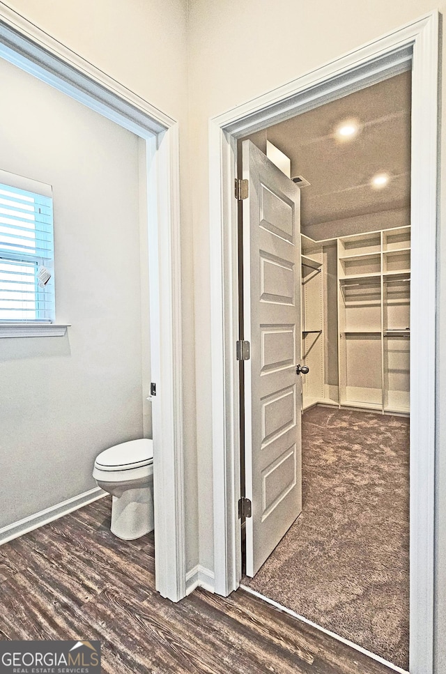 bathroom with wood finished floors, toilet, and baseboards