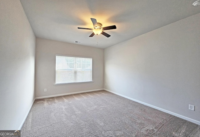 carpeted spare room featuring baseboards, visible vents, and a ceiling fan