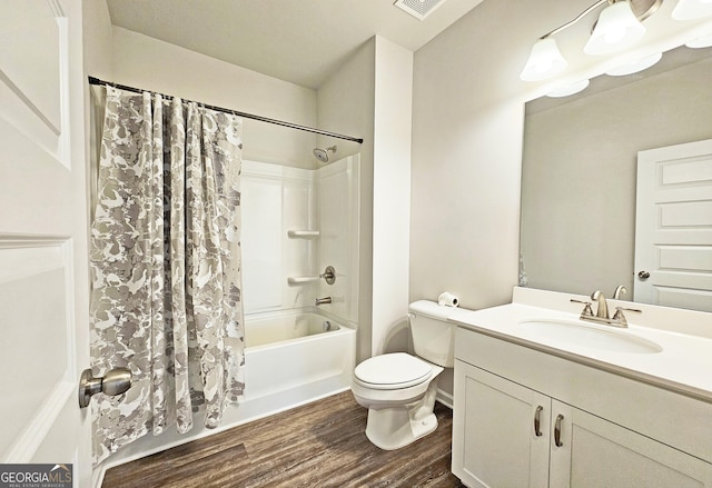 full bath featuring toilet, wood finished floors, visible vents, vanity, and shower / bath combo