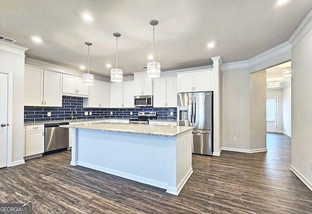 kitchen with appliances with stainless steel finishes, visible vents, a kitchen island, and dark wood-style floors