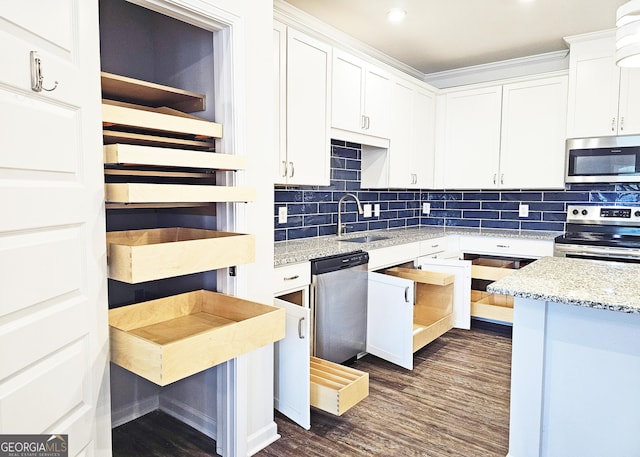 kitchen with dark wood-style floors, stainless steel appliances, tasteful backsplash, white cabinets, and a sink