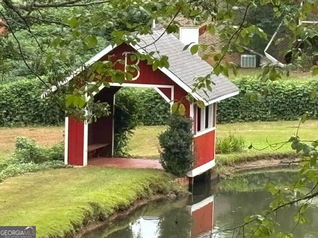 exterior space featuring a lawn and a water view