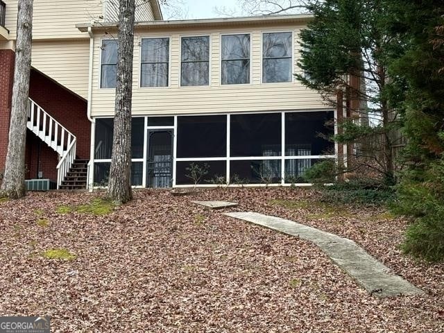 back of property with a sunroom and cooling unit