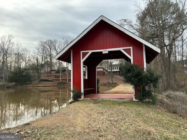 view of dock with a water view and a yard