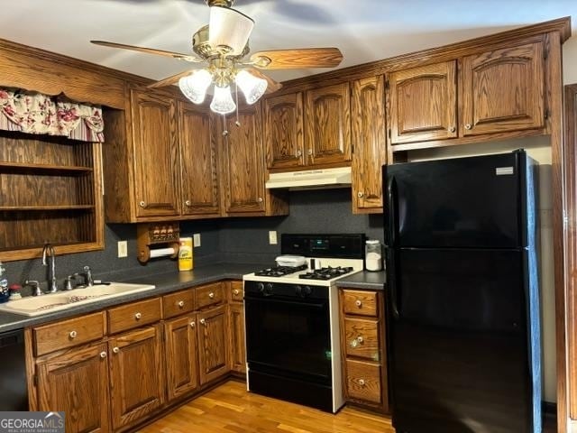 kitchen with black appliances, sink, ceiling fan, and light hardwood / wood-style floors