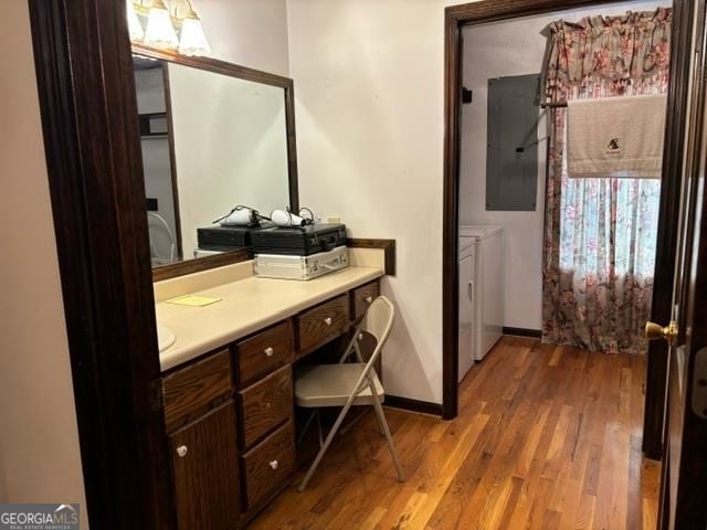 bathroom featuring electric panel, vanity, independent washer and dryer, and hardwood / wood-style flooring