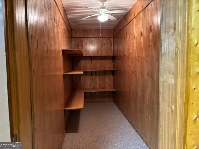 spacious closet with ceiling fan and light colored carpet