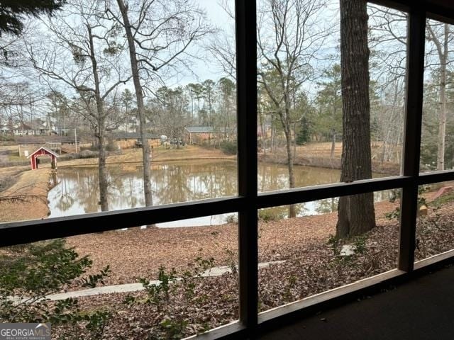 unfurnished sunroom featuring a water view