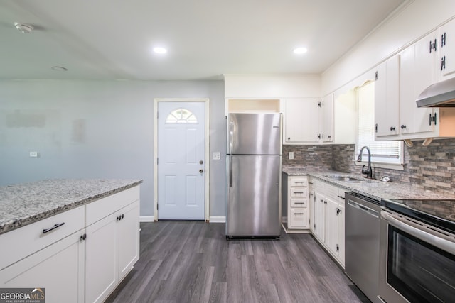 kitchen featuring white cabinets, sink, light stone countertops, dark hardwood / wood-style floors, and appliances with stainless steel finishes