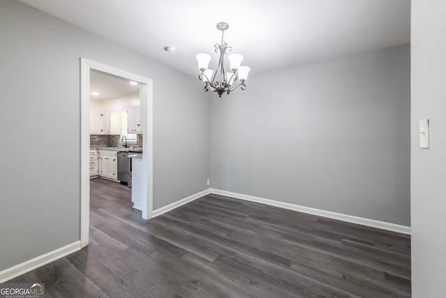 unfurnished room featuring sink, dark hardwood / wood-style flooring, and a notable chandelier