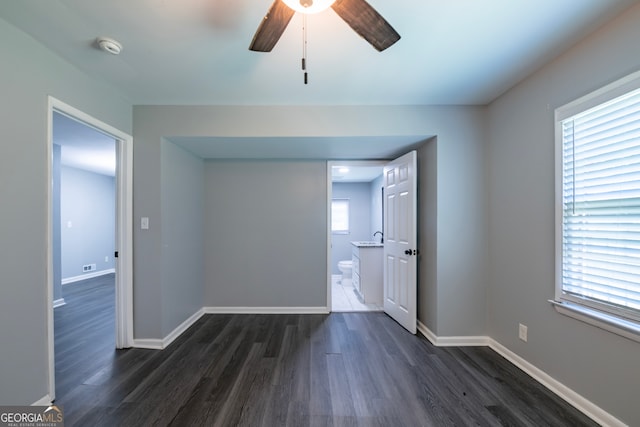 empty room featuring dark hardwood / wood-style flooring, a wealth of natural light, and ceiling fan