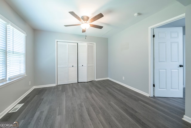 unfurnished bedroom with ceiling fan, dark hardwood / wood-style flooring, and a closet