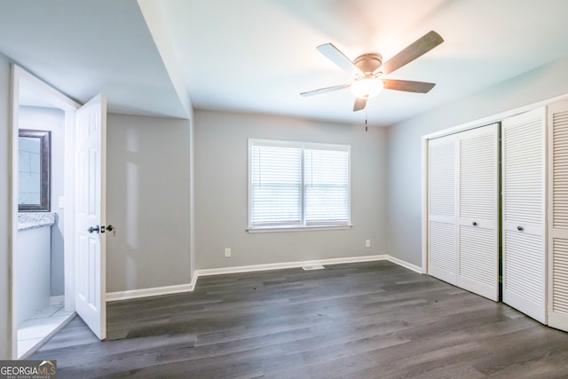 unfurnished bedroom with dark hardwood / wood-style floors, ceiling fan, and a closet