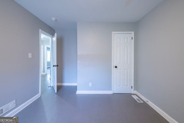 unfurnished room featuring concrete floors