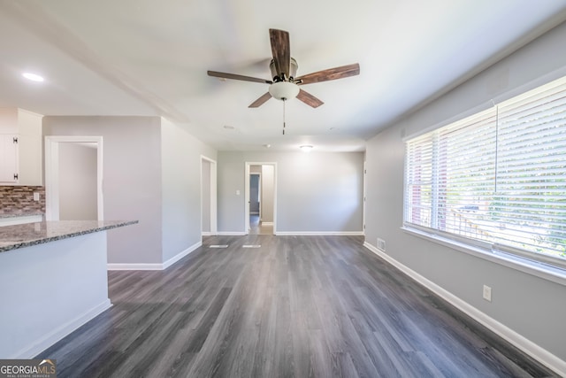 unfurnished living room with ceiling fan and dark hardwood / wood-style flooring