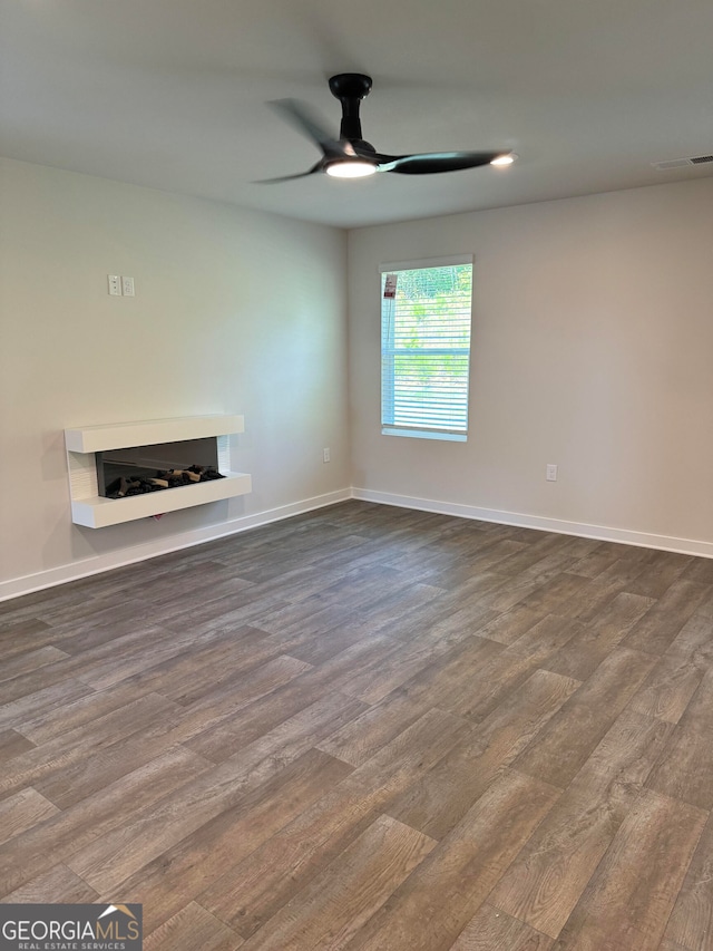 unfurnished living room with wood-type flooring and ceiling fan