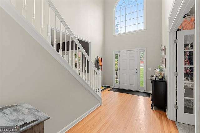 entryway featuring light hardwood / wood-style floors, a high ceiling, and plenty of natural light